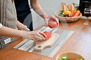 Lovely couple cooking their breakfast together in the kitchen, preparing salad`s ingredients together