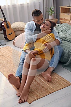 Lovely couple enjoying time together on floor in bedroom