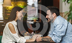 Lovely Couple Flirting And Talking Holding Hands Sitting In Cafe