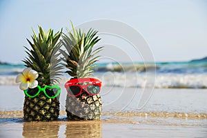 Lovely couple fresh pineapple put sun lovely glasses on clean sand beach with sea wave background