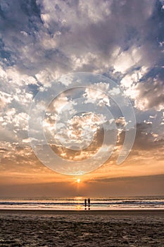 Lovely couple going to the ocean on the sunset