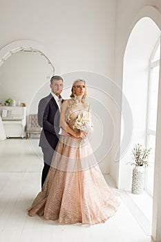 Lovely couple groom and bride in studio with light white interior. Wedding concept.