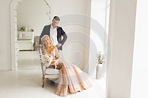 Lovely couple groom and bride in studio with light white interior. Wedding concept.