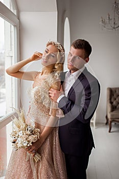 Lovely couple groom and bride in studio with light white interior. Wedding concept.