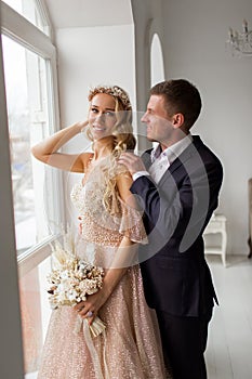 Lovely couple groom and bride in studio with light white interior. Wedding concept.