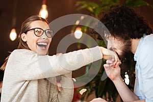 Lovely couple having a meeting at a cafe bar. Boy kissing girl`s hand