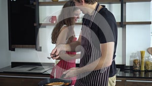 Lovely couple helping each other cooking at home during quarantine time