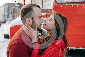 Lovely couple kiss on the background of a red bus