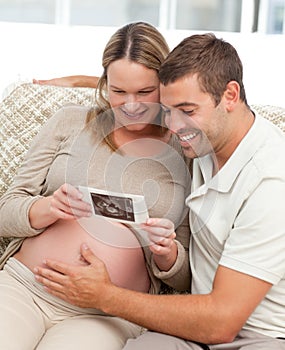 Lovely couple looking at an echography photo