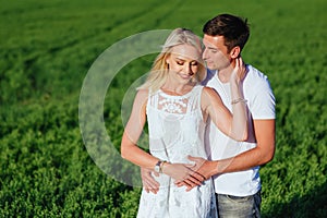 The lovely couple in love in a field.