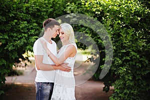 The lovely couple in love sitting on green grass.