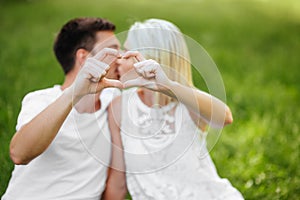 The lovely couple in love sitting on green grass.
