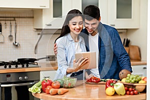 Lovely couple preparing salad together at home
