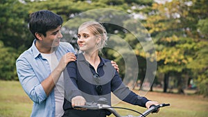 Lovely couple riding a bicycle in the park