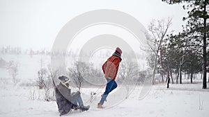 Lovely couple sledding on snowy winter day. Man pull sled with girlfriend on snowfall. Woman have fun and sledge
