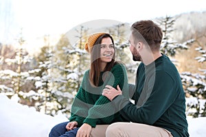 Lovely couple spending time together on snowy day. Winter vacation