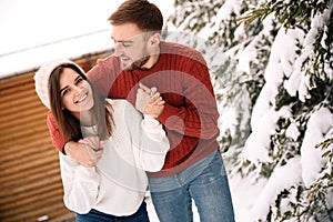 Lovely couple spending time together on snowy day. Winter vacation