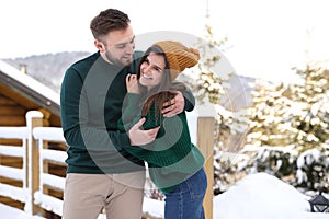 Lovely couple spending time together on snowy day. Winter vacation
