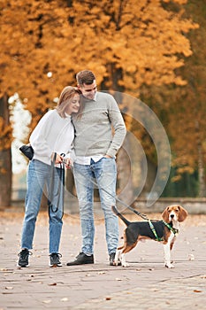 Lovely couple are with their cute dog outdoors