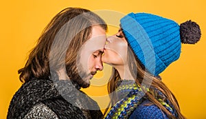 Lovely couple in warm clothes. Autumn or winter time. Woman kisses man in forehead. Stylish family.