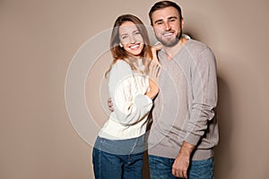 Lovely couple in warm sweaters on beige background
