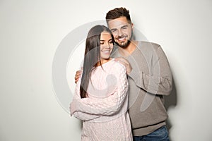 Lovely couple in warm sweaters on light background