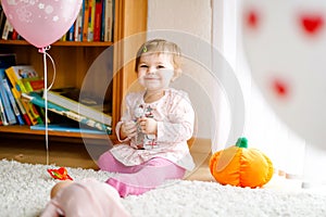 Lovely cute beautiful little baby girl playing with educational toys at home or nursery. Happy healthy child having fun