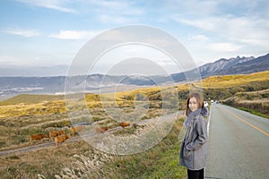 Lovely cute japanese girl standing on Aso active volcano background with smoke at Mount Aso Nakadake, Kumamoto