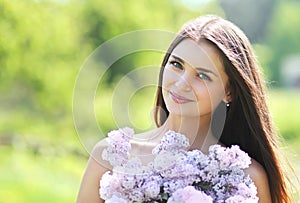 Lovely cute smiling girl with a bouquet of lilacs