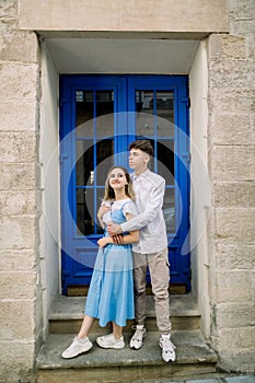 Lovely date on the street. Happy hipster young couple, handsome man with his attractive girlfriend in blue dress