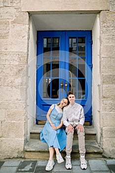 Lovely date on the street. Happy hipster young couple, handsome man with his attractive girlfriend in blue dress