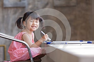 Lovely face of toothy smiling asian children practive to writing