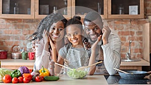 Lovely family cooking healthy dinner together at kitchen