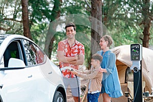 Lovely family recharge EV car with EV charging station in campsite. Perpetual