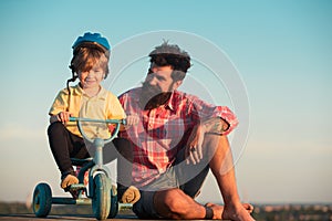 Lovely father teaching son riding bike. Fatherhood kids caring as dad and children family. Husband relationship with son