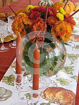 Lovely flowers, candles and multicolored pumpkins adorn a festive table