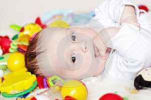 Lovely four-months baby among toys