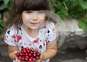 Lovely girl with fresh berries cherries in the garden.