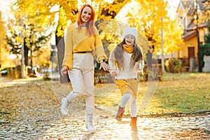 Lovely girl with her mom having fun on the walk. Autumn holidays, lifestyle