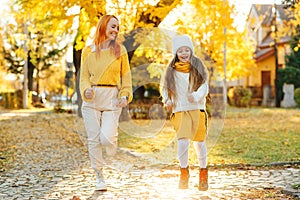 Lovely girl with her mom having fun on the walk. Autumn holidays, lifestyle