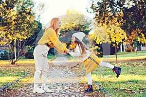 Lovely girl with her mom having fun on the walk. Autumn holidays, lifestyle