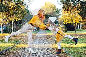 Lovely girl with her mom having fun on the walk. Autumn holidays, lifestyle