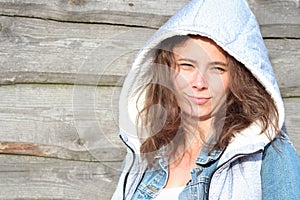 Lovely girl model against a wooden fence. In-country life of pretty young woman. Smile girl student on summer holidays