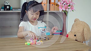 Lovely girl playing with teddy bear in living room