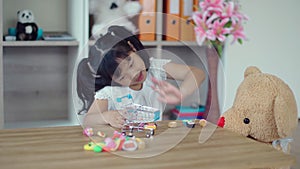 Lovely girl playing with teddy bear in living room