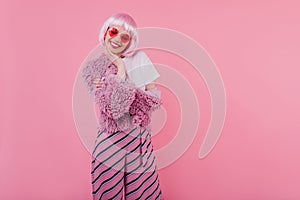 Lovely girl with short pink hair laughing with eyes closed. Studio photo of refined young lady wear