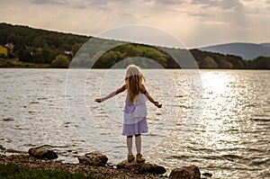 Lovely girl standing at the pond enjoying the moment