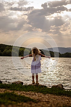 Lovely girl standing at the pond enjoying the moment