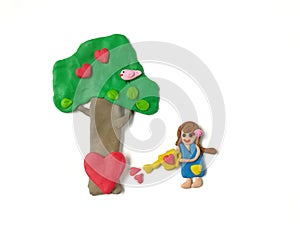 Lovely girl watering tree, bird and red heart plasticine clay, beautiful decorate dough