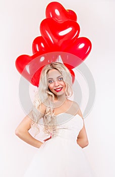 Lovely girl in a white dress with red balloons. Romantic concept.